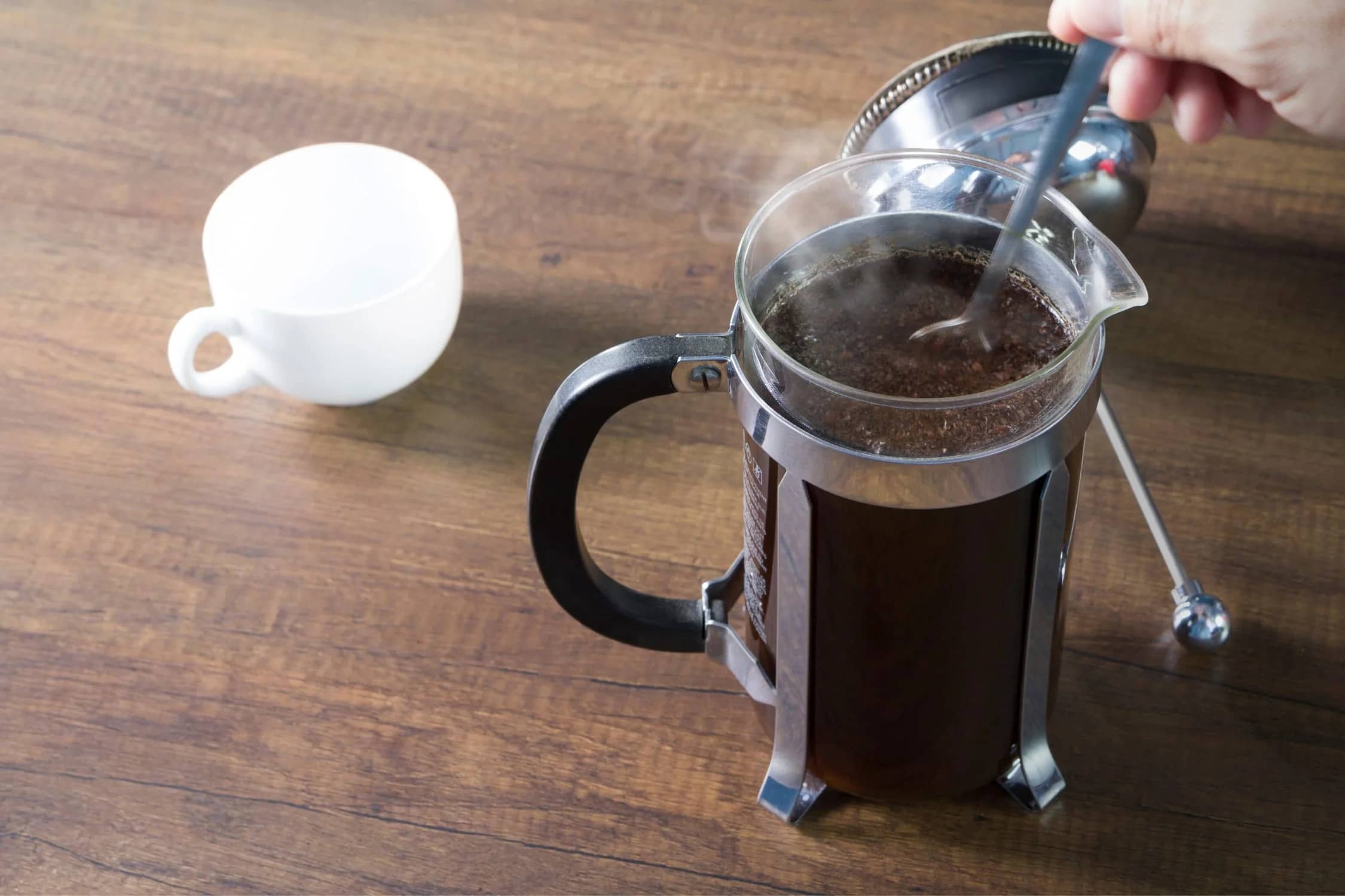 Ethiopian coffee beans next to a glass French press ready for brewing