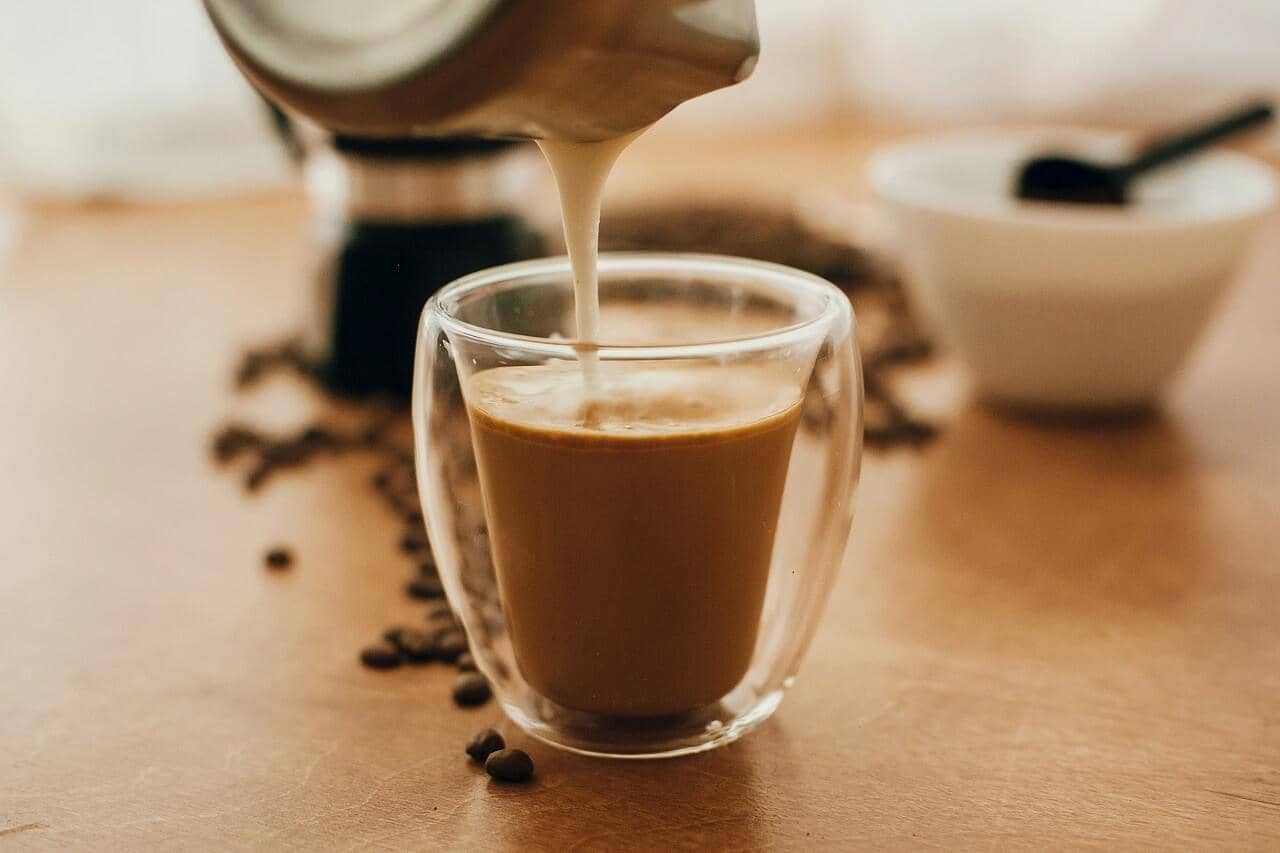 Ethiopian decaf coffee beans beside a steaming pour-over cup on a Canadian wood table