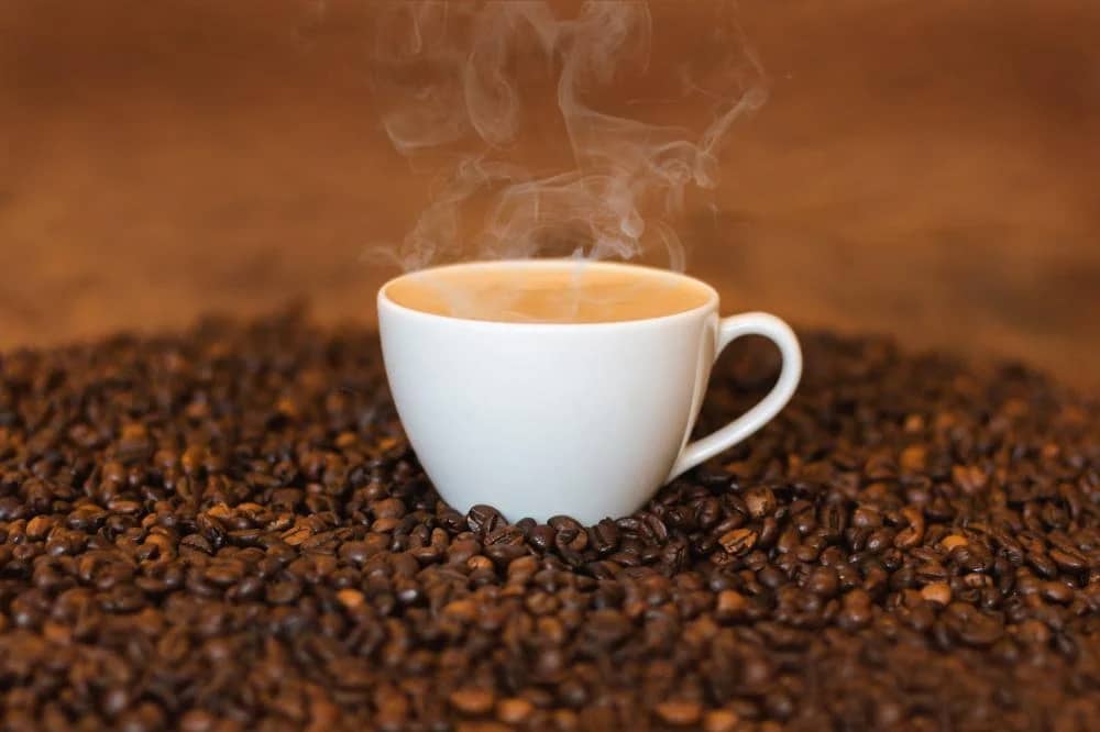 Cup of Ethiopian single-origin coffee with roasted beans, highlighting health benefits of Arabica coffee